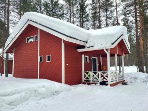 阿卡斯洛姆波罗Mäntymajat的一座红房子,上面有雪