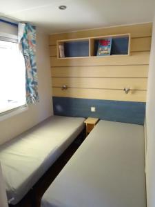 勒格罗-迪鲁瓦Camping Vagues Océanes的小房间设有两张床和窗户