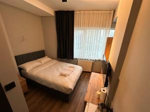 伊斯坦布尔Lucca Suites Hotel的一间小卧室,配有床和窗户