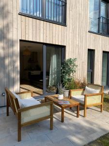 ĶesterciemsAlbatross Weekend: seaside apartment with a sunny terrace的庭院配有三把椅子和一张桌子。