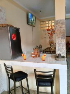 科帕卡巴纳Villa Bella Copacabana的厨房柜台配有两把椅子和冰箱
