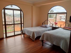 科帕卡巴纳Villa Bella Copacabana的带2扇大窗户的客房内的2张床