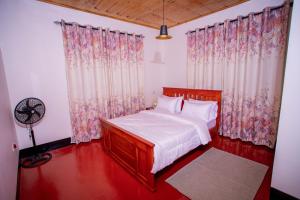 莫希Royal Homestay的一间卧室配有床、窗帘和风扇