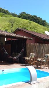 马卡埃Casa da Lu的一个带吊床和房子的度假胜地