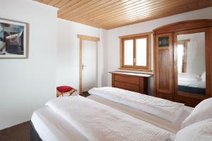CavagnagoCasa Bubeck的一间卧室设有两张床和木制天花板