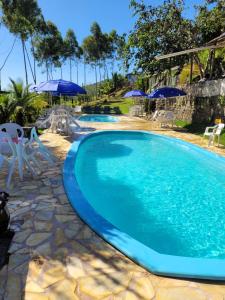 乌巴图巴Refugio de Itamambuca的一个带椅子和遮阳伞的大型游泳池