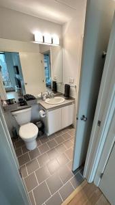 温哥华District West的一间带卫生间、水槽和镜子的浴室