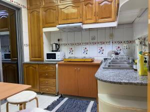 阿布扎比J & F Homestay - Abu Dhabi的一个带木制橱柜和水槽的厨房