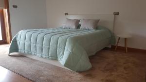 维拉诺瓦-德法马利Oktavihu House的卧室内的一张带绿色棉被的床