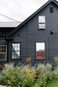 米斯蒂克Eileen of Mystic的院子里的黑色房子,带窗户和鲜花