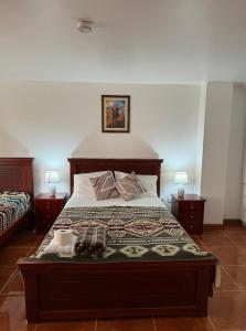奥塔瓦洛Kimsa Wasi III的一间卧室配有一张床和两张带台灯的桌子。