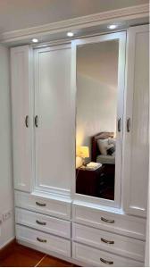 奥塔瓦洛Kimsa Wasi III的客房内的白色大橱柜,配有镜子