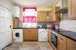 伦敦Hatton Homes - Thackeray Avenue的厨房配有洗衣机和窗户。