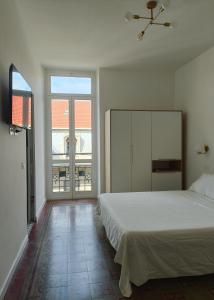 萨沃纳Noliday Savona Center Art Deco Apartment的卧室设有白色的床和大窗户
