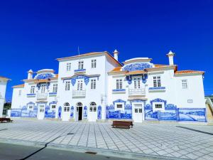 阿威罗Sal, Terra e Mar的一座白色的大建筑,上面有蓝色的瓷砖