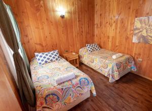 普孔Hotel Catripulli的木墙客房的两张床