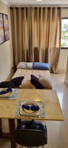 阿瓜斯克拉腊斯Apartamento Perfeito águas claras的客房设有两张床和一张木桌。
