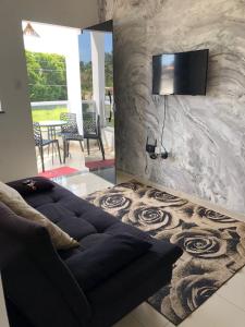 盖比姆Beira Mar Residencial的客厅配有沙发和墙上的电视