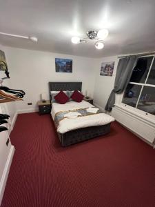 惠特比HELIN’s Cottage的一间卧室配有一张床,铺有红色地毯