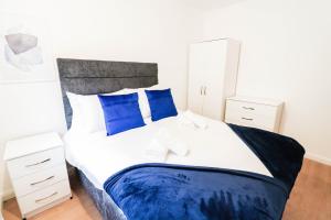卢顿5 bed house with driveway!的一间卧室配有一张带蓝色枕头的大床