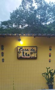 马卡埃Casa da Lu的黄色建筑一侧的标志