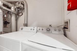拉德洛Winterplace Getaway的洗衣房内配有两台白色洗衣机