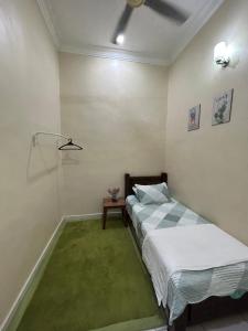 双溪大年HomestayMuslim Safiyya的一间卧室配有床和绿色地毯