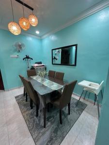 双溪大年HomestayMuslim Safiyya的一张带椅子的餐桌和蓝色的墙壁