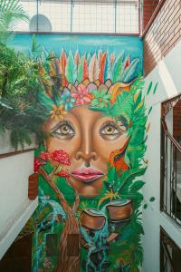 麦德林Hostal Pura Vida la 70的墙上有植被的女人的壁画