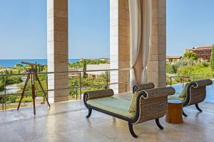 RomanuThe Romanos, a Luxury Collection Resort, Costa Navarino的阳台配有桌椅,享有海景。