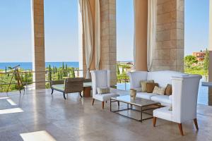 RomanuThe Romanos, a Luxury Collection Resort, Costa Navarino的客厅配有白色家具,享有海景。