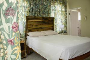 特雷热比奇DEMAROYS的一间卧室配有一张带花卉壁纸的床