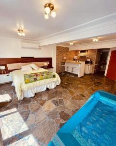 巴拉那Peatonal Suites Paraná的一间带大床的卧室和一个游泳池