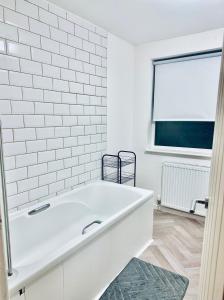 泰恩河畔纽卡斯尔*Newcastle City* Modern 2 Bedroom House的带窗户的浴室内的白色浴缸