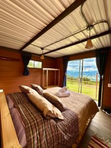 塔比奥Refugio Aventura, romántico glamping montañero的一间卧室设有一张大床和大窗户