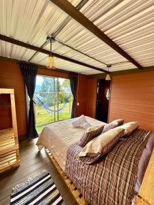 塔比奥Refugio Aventura, romántico glamping montañero的一间卧室设有一张大床和大窗户