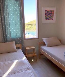 Wando莞岛尼西亚宾馆的带窗户的客房内的两张床