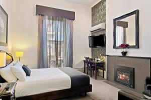 巴拉腊特利迪亚德海瑞特品质酒店的酒店客房配有一张床和一个壁炉。