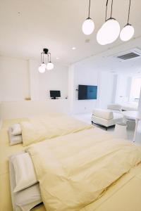 高知「まちのアトリエ」STAY UWU 004的卧室拥有白色的墙壁和一张黄色床单