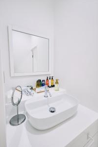 高知「まちのアトリエ」STAY UWU 004的白色的浴室设有水槽和镜子