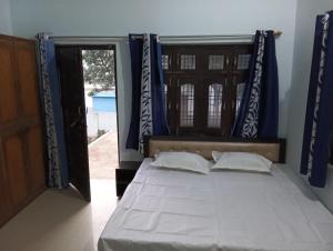 FaizābādMAHENDRA HOME STAY的一间卧室配有蓝色窗帘的床