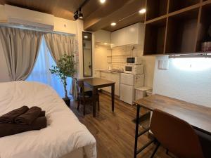 东京Cozy inn Oyama的配有床和桌子的房间以及厨房