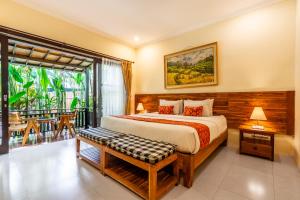 乌布Meruhdani Boutique Hotel Ubud的一间带大床的卧室和一个阳台