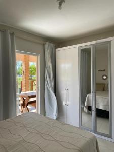 埃斯坦西亚Casa Térrea - Villa das Águas - Praia do Saco的一间卧室设有一张床和一个滑动玻璃门