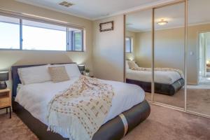 珀斯The Stirling - Experience the Sea to City Lifestyle的一间卧室配有两张床和镜子