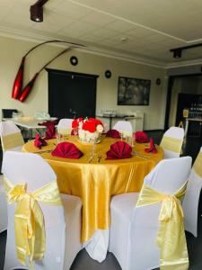 格伦因尼斯Club Hotel的一张桌子上放着黄色的桌布和红色的鲜花