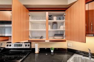 拉斯维加斯Royal Oasis Suite的厨房配有木柜,在架子上摆放着餐具