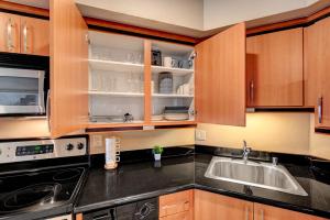拉斯维加斯Royal Oasis Suite的一个带木制橱柜和水槽的厨房