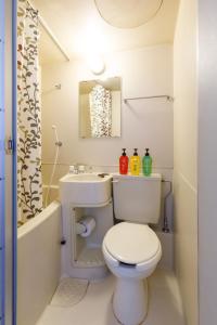 伊那市ホテル青木的浴室配有卫生间、盥洗盆和浴缸。