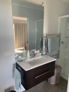 卡蒂卡蒂Kaimai Range Country Getaway的一间带水槽和大镜子的浴室